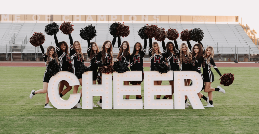 Cheerleaders with giant light up letters